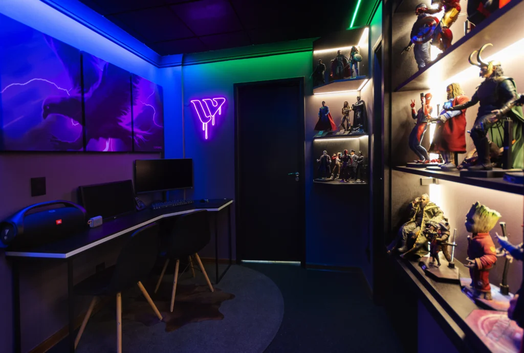 Quarto com iluminação gamer vibrante, destacando LEDs coloridos nas paredes e prateleiras, criando um ambiente imersivo para jogos e exibição de colecionáveis.