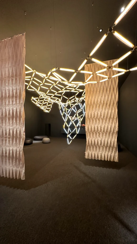 <img src="ambiente-contemporaneo-iluminacao-creative.webp" alt="Ambiente contemporâneo com iluminação criativa e divisórias de papel texturizado, destacando um design minimalista e moderno.">