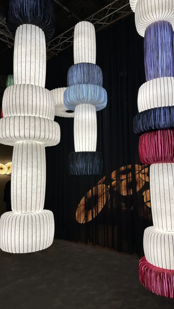 <img src="luminaraias-modernas-penduradas.webp" alt="Luminárias modernas penduradas em ambiente escuro, com design em formato cilíndrico e cores variadas, incluindo azul, branco e vermelho, criando uma atmosfera elegante.">
