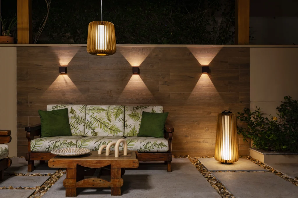 <img src="varanda-modernarusticaconfortavel.webp" alt="Terraço de varanda moderna com móveis de madeira, sofá com almofadas verdes, iluminação ambiente aconchegante e plantas decorativas, ideal para relaxar.">