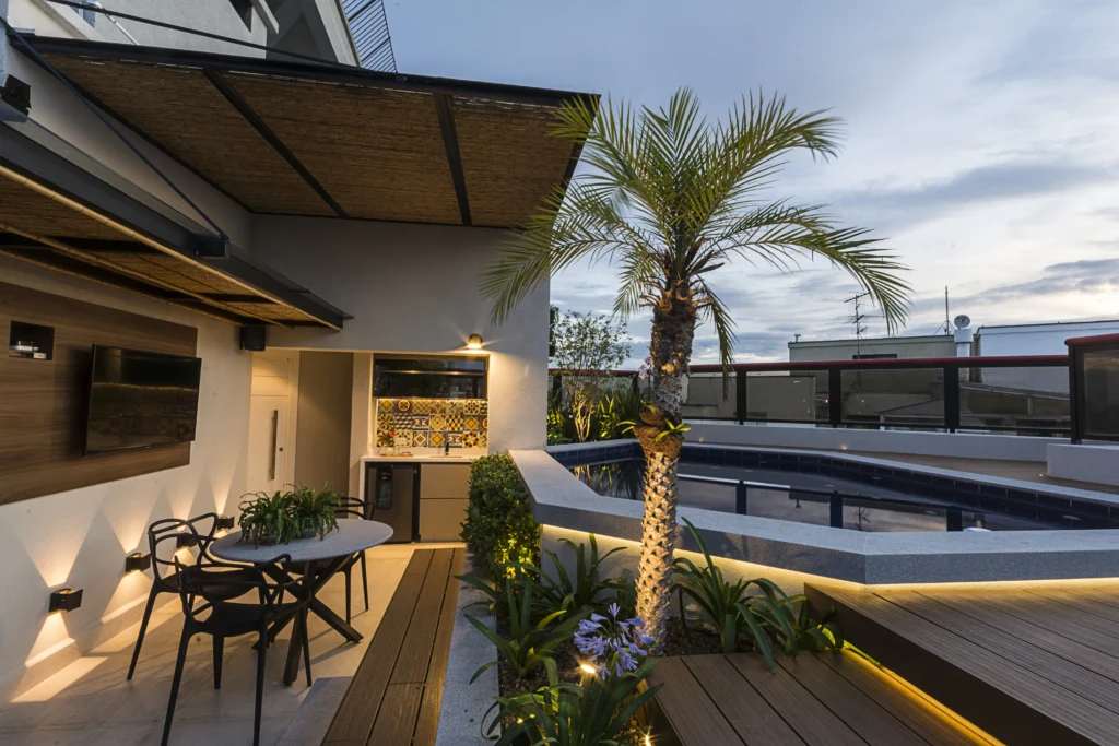 <img src="espacoexternoareaelazerpiscinajardimmoderno-jpg.webp" alt="Imagem de um espaço externo com área de convivência, piscina, jardim com palmeira, decoração moderna e iluminação aconchegante, ideal para lazer ao ar livre.">