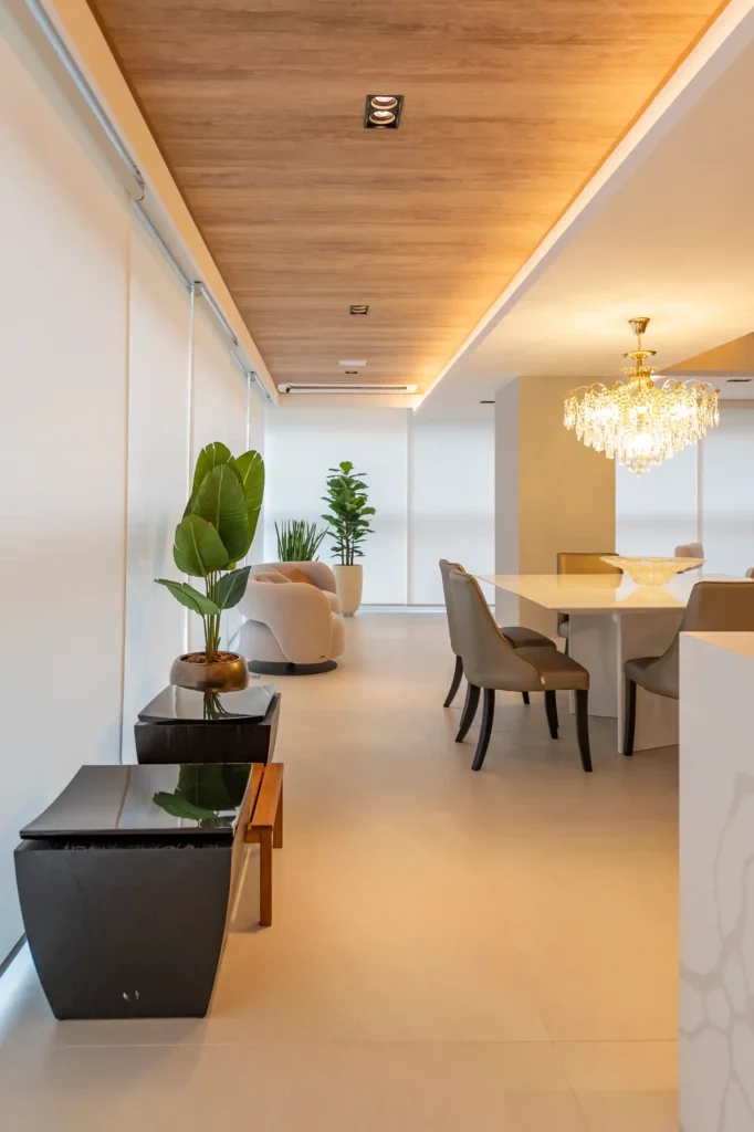 <img src="ambiente-moderno-decoracao-elegante-jpg.webp" alt="Ambiente moderno com decoração elegante, featuring plantas verdes, mesa de jantar branca e luminária de cristal, ideal para arquitetura e design de interiores.">