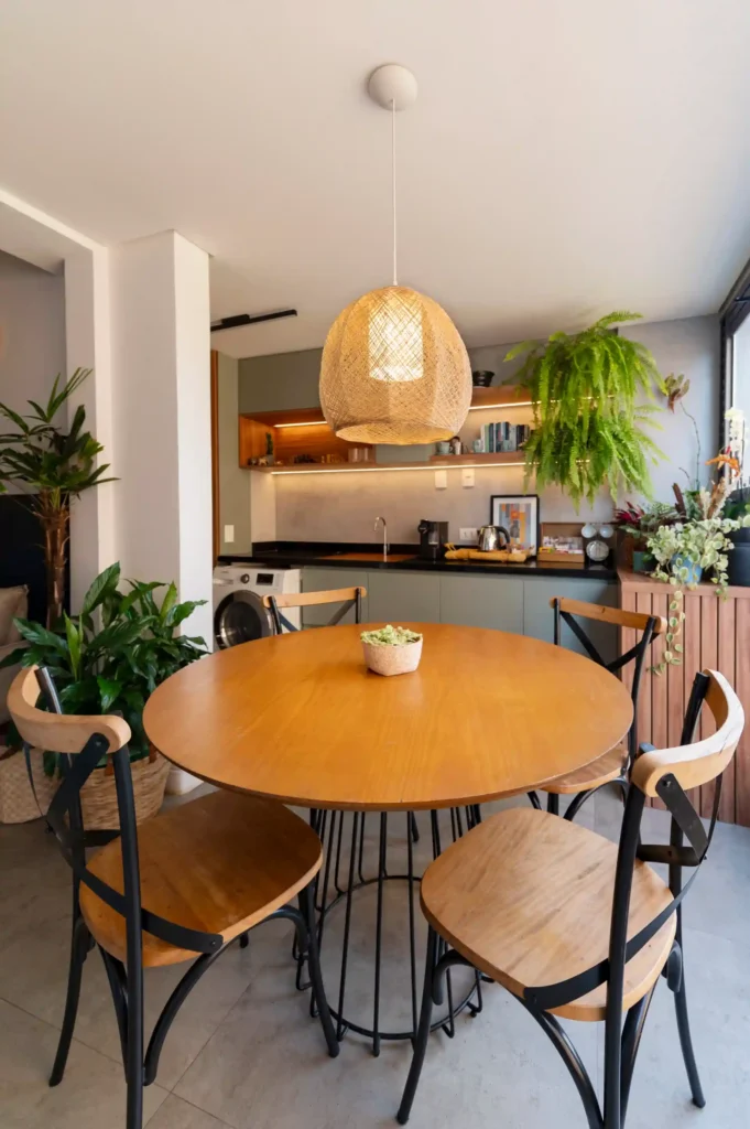 <img src="sala-de-jantar-moderna-com-mesa-redonda.webp" alt="Sala de jantar moderna com mesa redonda de madeira e cadeiras pretas. Ambiente iluminado e decorado com plantas, ideal para refeições aconchegantes.">
