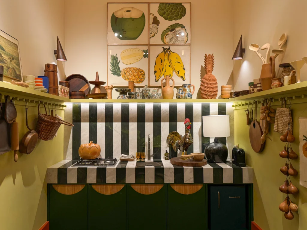 <img src="cozinha-decorada-objetos-decoracao-utiilhos-modernose-aconchegante.webp" alt="Cozinha decorada com objetos de decoração, quadros de frutas, vasos, iluminação e utensílios de cozinha moderna, criando um ambiente aconchegante e estiloso.">