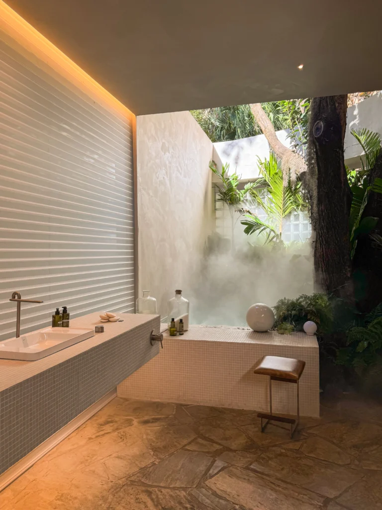 <img src="banheiraarlivrepo-relaxamento-natureza-jpg.webp" alt="Banheira de hidromassagem ao ar livre integrada à natureza, com paredes brancas, plantas verdes e decoração minimalista, ideal para relaxamento.">