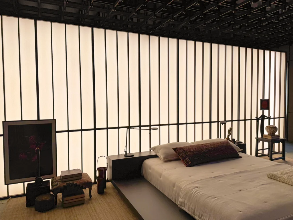 <img src="quarto-moderno-ambiente-elegante-minimalista-jpg.webp" alt="Quarto moderno com parede de iluminação em fundo e decoração minimalista, incluindo uma cama, livros, e objetos de design, ambiente aconchegante e elegante.">