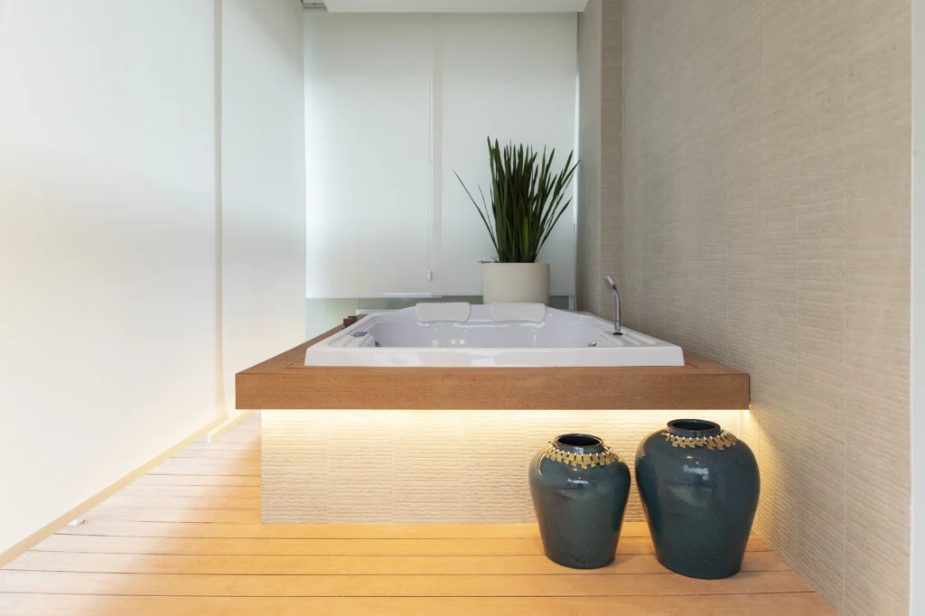 <img src="banheira-de-hidromassagem-moderna-espaco-relaxante-elegante.webp" alt="Banheira de hidromassagem moderna em um ambiente elegante com iluminação suave, plantas verdes e vasos decorativos preta e azul, criando um espaço relaxante e sofisticado.">