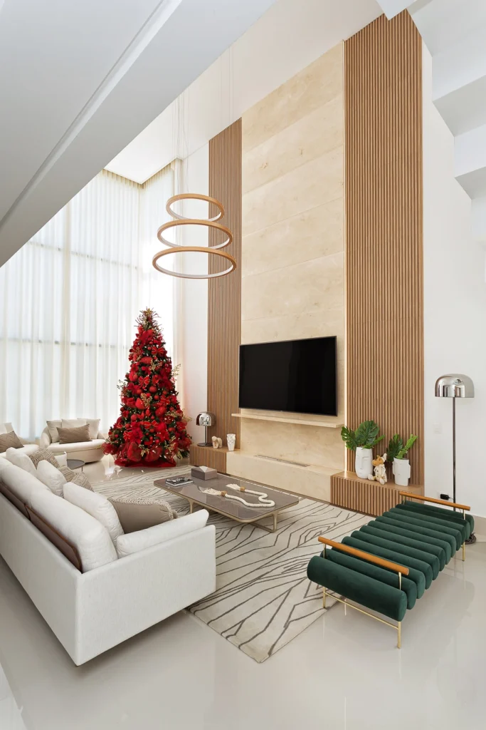 <img src="sala-estar-moderna-decorada-para-natal-jpg.webp" alt="Sala de estar moderna decorada para Natal com árvore de Natal vermelha, sofá branco, detalhes de madeira, televisão de tela plana e plantas verdes, ambiente elegante e acolhedor.">