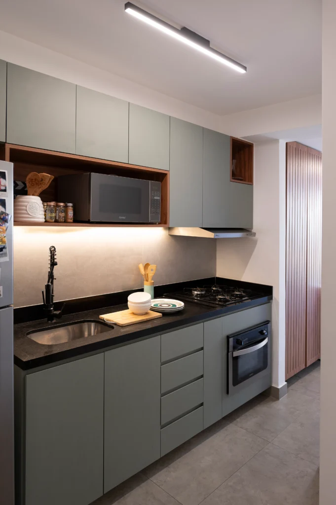 <img src="cozinha-moderna-armarios-cinza-bancada-preta-microondas-fogao-a-gas.webp" alt="Imagem de uma cozinha moderna com armários cinza, bancada preta, micro-ondas embutido, fogão a gás e itens de cozinha decorativos, ideal para experimentar o melhor estilo de cozinha compacta e funcional.">
