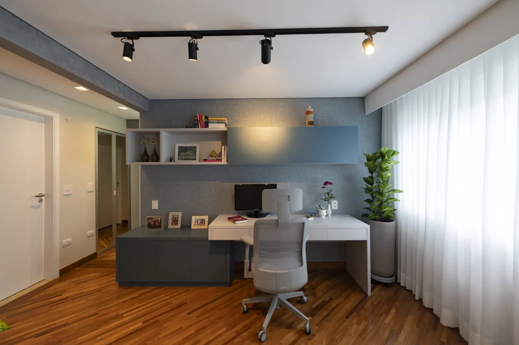<img src="escritorio-moderno-trabalho-home-office-jpg.webp" alt="Imagem de um escritório moderno com móveis brancos, prateleiras decorativas, uma planta alta ao lado e iluminação dirigida do teto, ideal para trabalho remoto ou estudos.">