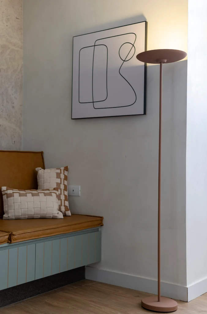 <img src="decoracao-sala-moderno-quadro-abstrato-lampada-de-pie.webp" alt="Decoração moderna de sala com quadro abstrato, piso de madeira, almofadas decorativas no sofá e luminária de chão em ambiente com iluminação suave.">
