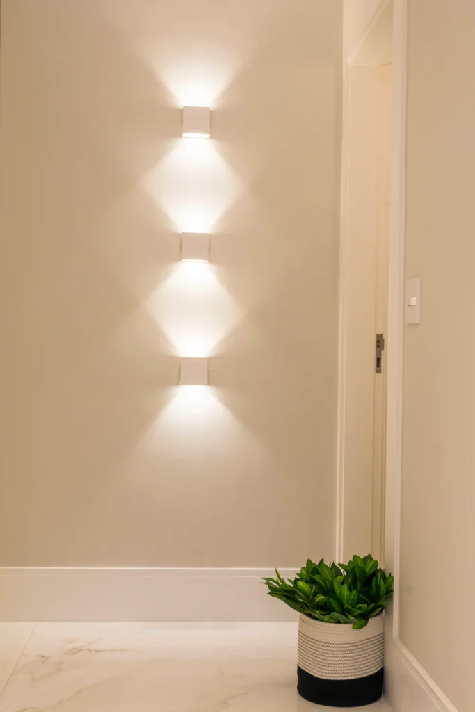 <img src="decoracao-moderno-com-iluminacao-e-planta.webp" alt="Decoração moderna com iluminação de parede e planta em vaso, ambiente elegante e aconchegante.">