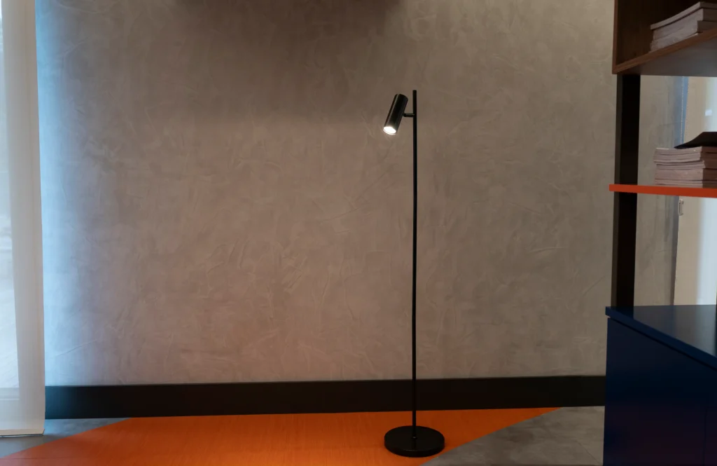 <img src="luminaria-de-pie-modernista-ambiente-interno.webp" alt="Luminária de pé moderna em ambiente interno com parede neutra, criando um aspecto minimalista e elegante para decoração de escritório ou sala de estar.">