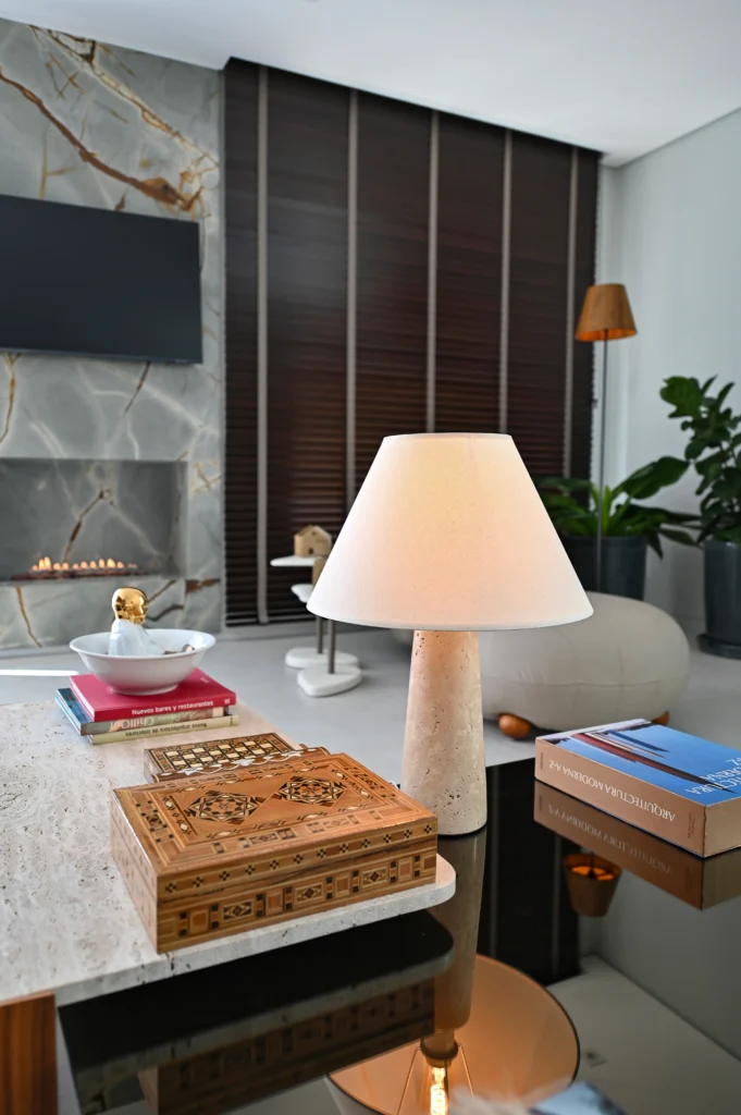 <img src="sala-moderno-aconchegante-lampada-e-plantas.webp" alt="Sala moderna com iluminação aconchegante, mesa de centro com livros e jogos de tabuleiro, decoração elegante com luminária de mesa e plantas.">
