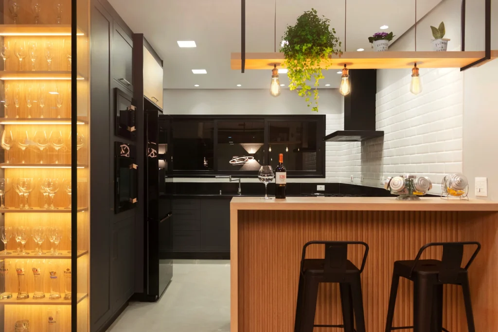 <img src="cozinha-moderna-decoracao.webp" alt="Imagem de uma cozinha moderna com ilha de madeira, armários pretos, parede de tijolos brancos e iluminação aconchegante, ideal para decoração de casa">