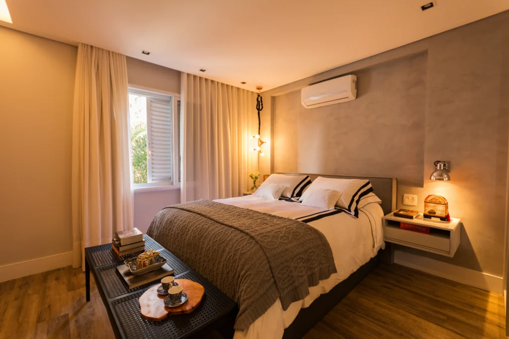 <img src="quartoaconchegantecameradeluxe.webp" alt="Quarto aconchegante com cama de casal, iluminação suave, ventilador de parede, cortinas claras e decoração moderna, ideal para hospedagem confortável.">