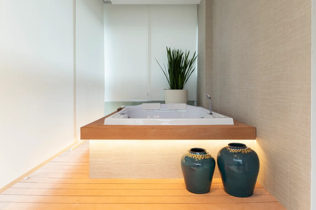 <img src="banheira-hidromassagem-moderno-elegante.webp" alt="Banheira de hidromassagem moderna em um ambiente elegante com decoração minimalista, incluindo vasos decorativos e plantas verdes, perfeita para relaxamento">