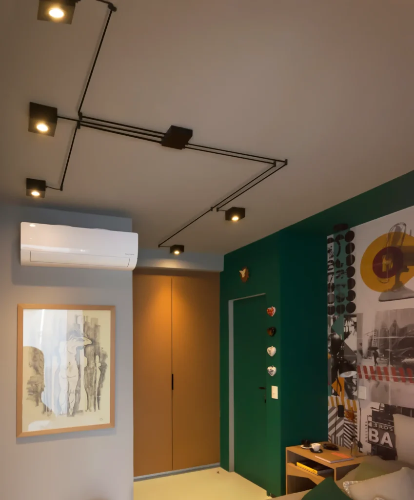 Quarto contemporâneo com iluminação de fios aparentes no teto, proporcionando luz de destaque sobre as paredes decoradas.